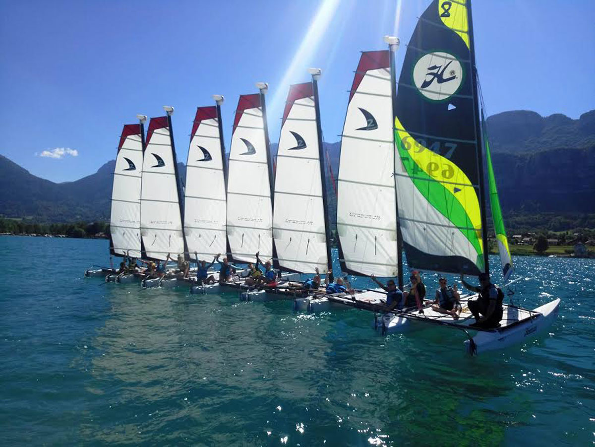 Navigation en Hobie Bravo sur le lac d'Annecy avec un panorama de montagnes en arrière-plan.